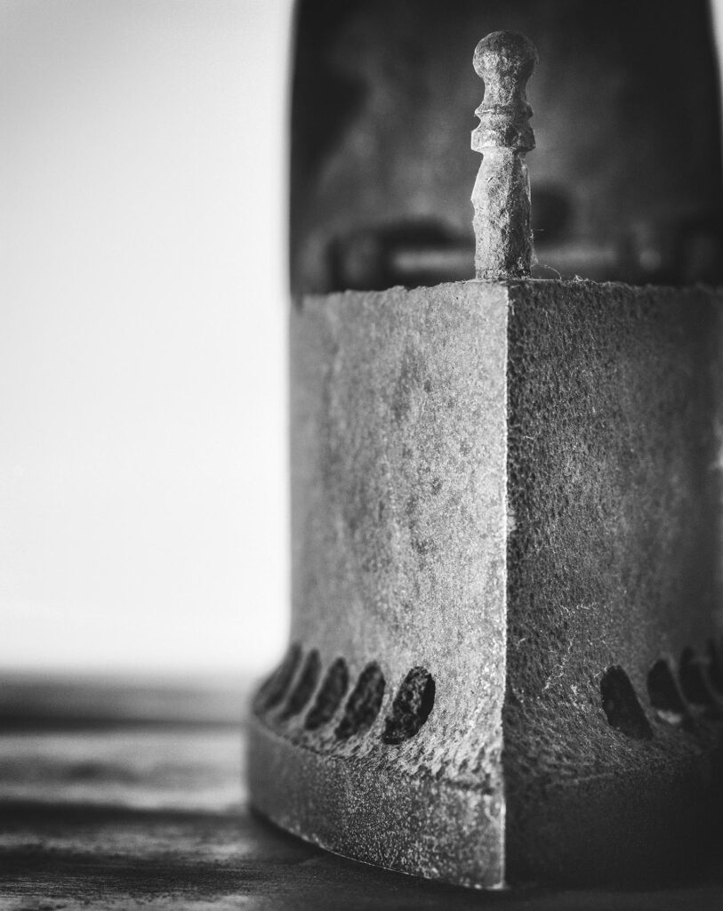 An old object photographed in foregraund with a clear white background. Namely an iron steel